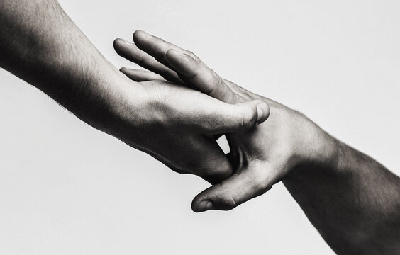 Man gives his hand to a woman. Two hands, helping arm of a friend, teamwork. Rescue, helping gesture or hands. Black and white