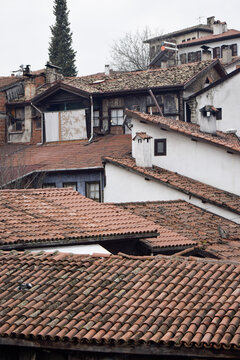 View of terracotta rooftops cascade down the hillside, punctuated by white walls and dark wooden accents under a muted sky, Safranbolu, Karab&Atilde;&frac14;k, T&Atilde;&frac14;rkiye.