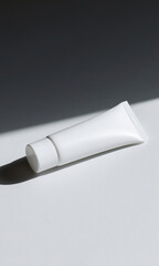 Minimalist Beauty Product A Clean White Tube with Shadow Play on a Light Background.