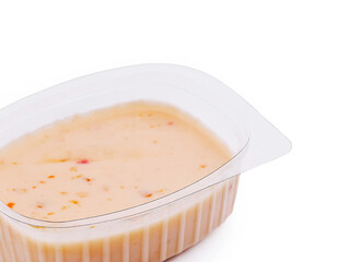 Creamy dip served in a plastic container with a rustic design