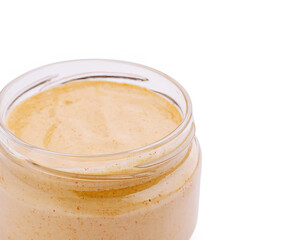 Creamy nut butter in a glass jar on a white background ready for use