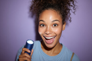 joyful teenager holding emoji flashlight beams with happiness against soft lavender backdrop