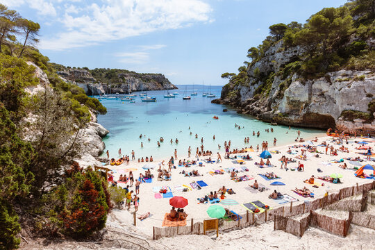 Cala Macarelleta beach crowded in summer, Menorca island, Spain