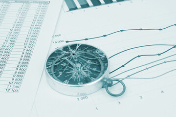 Broken compass on financial document close-up. Concept of loosing financial guidance and bad advise.