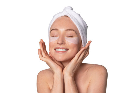 Woman enjoying a skincare routine with a towel on her head and under-eye patches in an indoor setting during the day