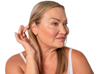 Obraz premium Senior woman showing natural beauty with soft smile while touching her hair on plain background