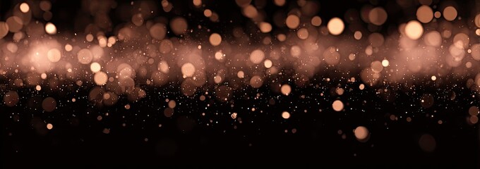 Fototapeta premium Abstract bokeh background of light reddish-brown circles on a black backdrop