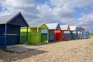 colourful wooden beach huts at the seaside. traditional cabins on stony beach