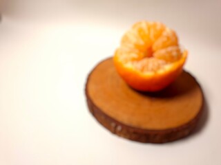 Blurred close-up of a fresh peeled mandarin orange on a pieces of wood. Minimalist food photography with soft focus, warm tones, and natural citrus detail for modern design use.