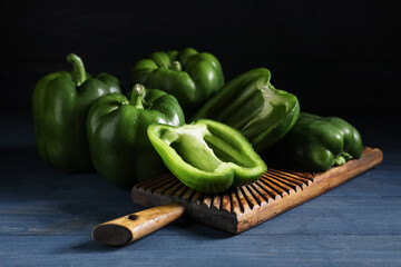 Cutting board with green bell peppers on blue wooden table