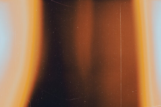 light leak overlay effect with scratch dust and blur light leaks,retro noisy film texture light leak flare on black background,abstract background with rays of orange light