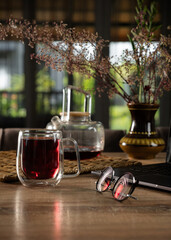 Cozy indoor setting featuring herbal tea, elegant glassware, and decorative plants in the afternoon light