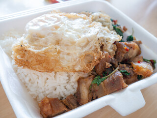 Crispy Pork Basil with Fried Egg in Foam Box Takeaway.