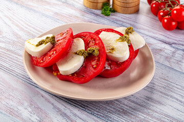 Italian Caprese salad with tomato, mozarella and pesto