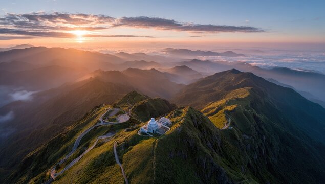 Sunset over mountain range with winding roads, scenic vista