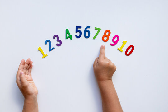 Child hands counting colorful numbers on white background