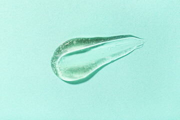 Sample of cosmetic gel on turquoise background, closeup