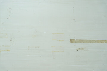 ざらざらの古い汚い壁のテクスチャー背景壁紙　凸凹の質感　傷ついた表面と張り付けたテープのあとの汚れ　アンティーク・ビンテージ