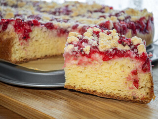 A piece of yeast cake with fruit on top and crumble, raspberry and currant cake