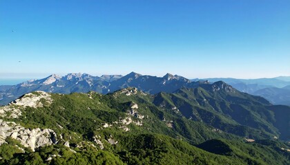 Obraz premium Majestic mountain vista rolling green hills with clear blue sky, and outdoor travel scenery.