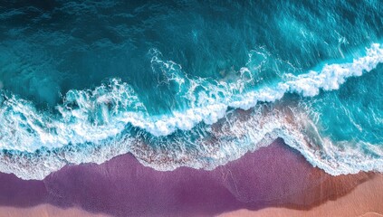 Fototapeta premium High-angle view of turquoise waves crashing on a pinkish-tan beach