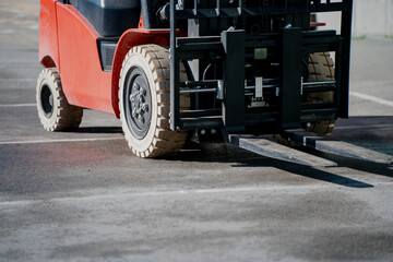 Forklift truck machinery detail with visible forks and rugged tires, heavy load mover for warehouse and logistics use, industrial transport vehicle for pallets, shipping and storage efficiency © K