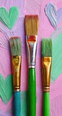 Fototapeta premium Three paintbrushes, vibrant colors, artistic backdrop