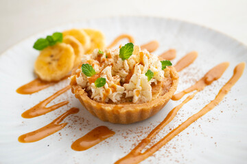 Banoffee tart filled with caramel, fresh banana and whipped cream.