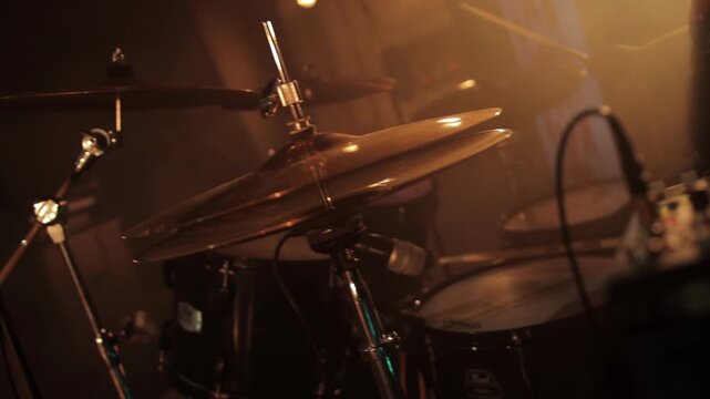 Professional drummer plays drum kit against smoke and lights on stage. Music concert, slow motion. Copy space for text