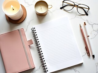 Spiral notebook, pink planner, pens, and candles on marble desk for workspace inspiration, journaling, and productivity