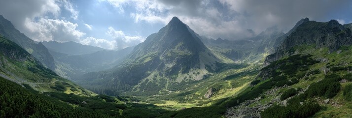 Panoramic view of a mountain valley. Lush green slopes and peaks rise into a cloudy sky