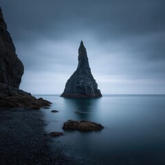 Dramatic, dark rock spire on calm water
