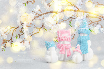 Happy snowmen family under a sakura branches. Cute greeting card, anniversary concept, birthday