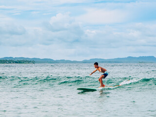A child surfing in Cloud 9 beach, Siargao Island, Philippines