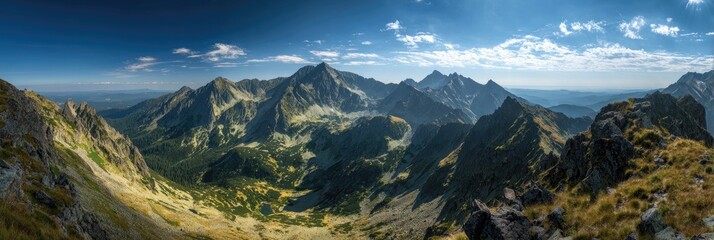 Panoramic mountain range vista.  Vast, rugged mountain peaks pierce a vibrant blue sky.  Green valleys and slopes are interspersed with rocky outcrops.  