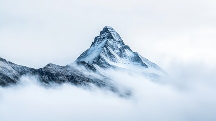 Snow covered mountain peak emerging from clouds