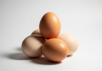 Pile of brown eggs isolated on white background in a studio setting