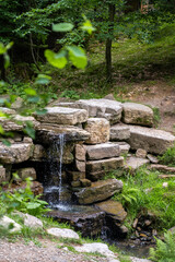 stone waterfall in a forest in a sunny day. high quality photo