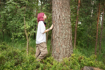 Young biologist exploring forest and examining tree bark