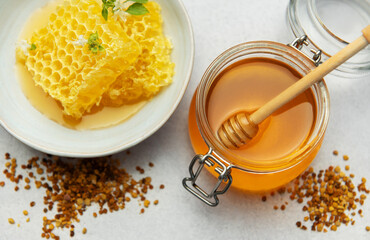Honey, honeycomb and bee pollen creating delicious golden composition