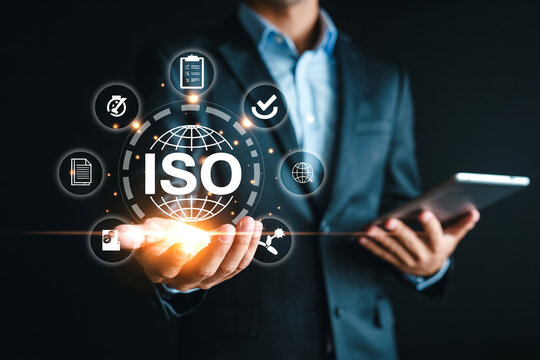 ISO Standards and Quality Management System Certification Concept with Businessman Holding Tablet and Digital Icons Representing Compliance and Global Best Practices - Powered by Adobe