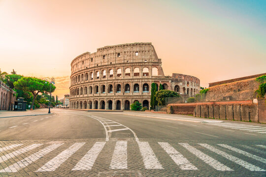 Colosseum exterior view with empty street at sunrise Rome Italy