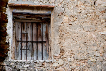 ventana vieja de madera con barrotes en una casa abandonada