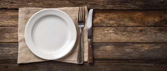 The elegant white plate set atop a rustic wooden table with cutlery.