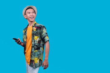 Happy Man In A Hawaiian Shirt And Hat, Holding A Phone, Looking Upward and Smiling Widely