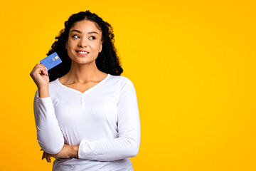 Ready For Shopping.Portrait of dreamy african american female holding credit card, pensive black...