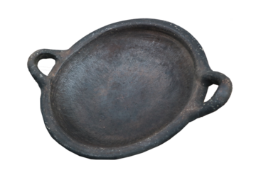 A round, blackened clay dish with two handles. It has a rustic appearance, suggesting it may be handmade and used for serving or cooking.
