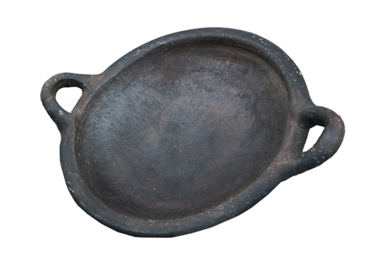 A round, blackened clay dish with two handles. It has a rustic appearance, suggesting it may be handmade and used for serving or cooking.