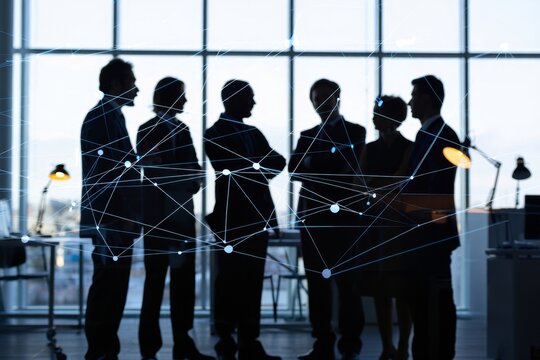 Silhouetted business team standing in front of a window with network connection overlayed
