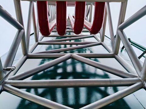 Industrial steel structure with red pipeline on green tank, engineering construction, refinery, petrochemical plant, factory piping system, structural design, heavy industry infrastructure, safety ins
